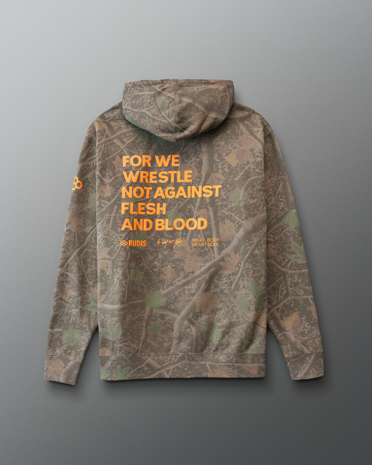 Camouflage hoodie with orange 'For we wrestle not against flesh and blood' text on the back against a gray background
