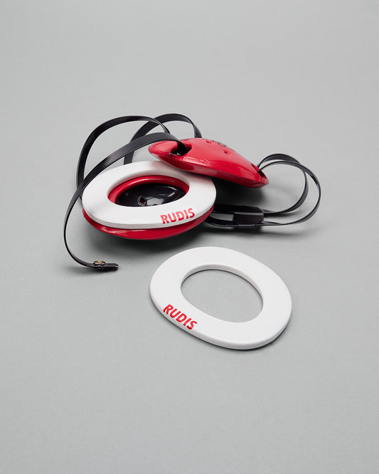 Red and white wrestling headgear extension pads with 'RUDIS' branding on a gray background