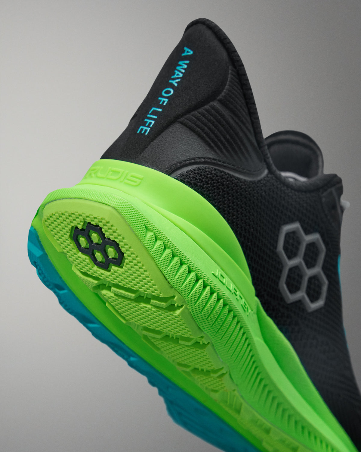 Black and green athletic shoe with brand logo on a gray background