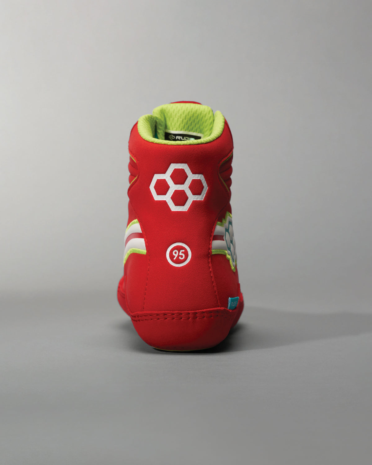 A vibrant red athletic shoe featuring a unique hexagonal design and bright green interior showcasing dynamic detailing