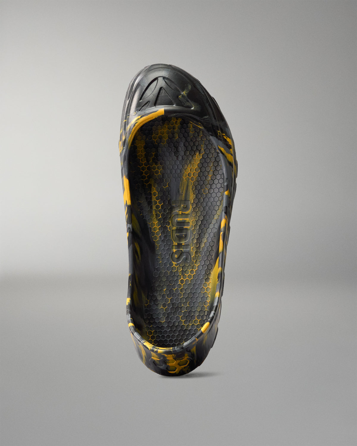 Top view inside the RUDIS black and yellow wrestling shoe cover showing the honeycomb-textured footbed and RUDIS branding.