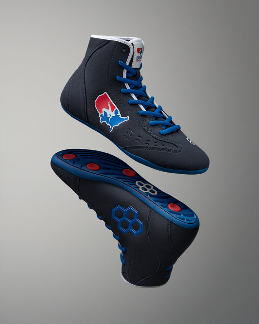 Black wrestling shoes with blue laces and red accents on a gray background