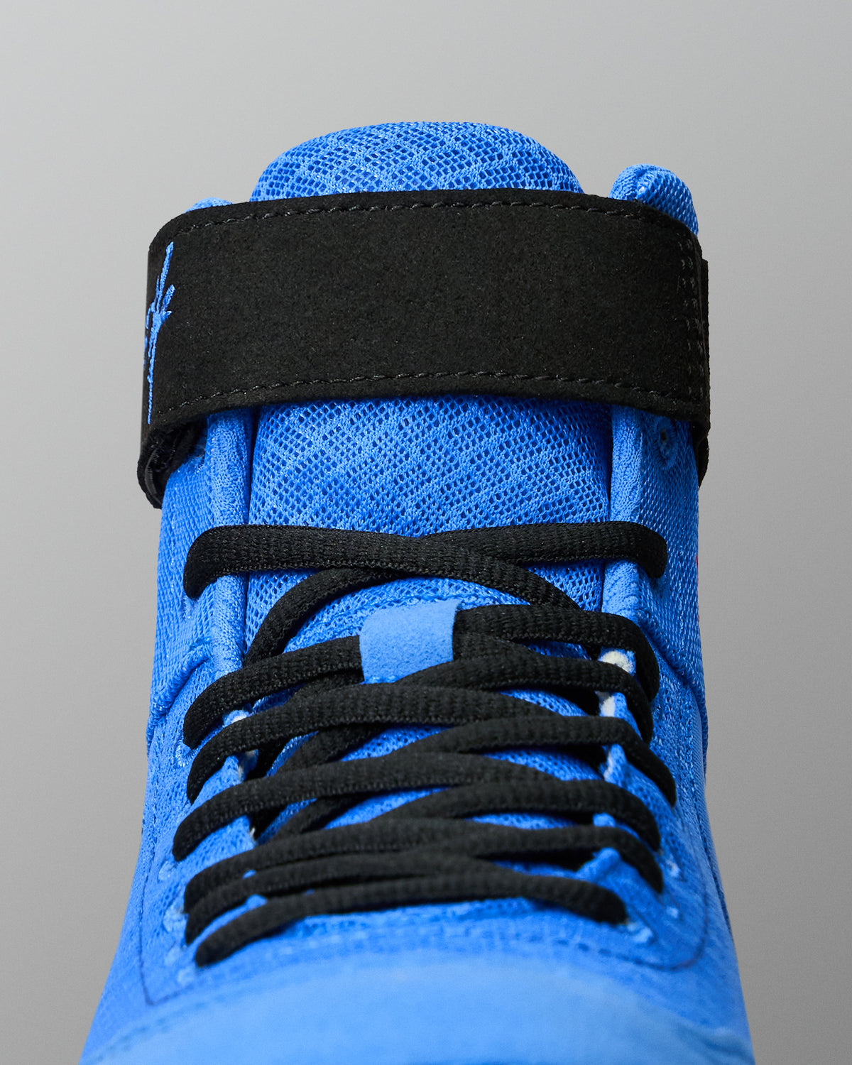 Close-up of RUDIS Samurai Speed Ikigai youth wrestling shoe showcasing textured blue mesh, black laces, and ankle strap stitching.