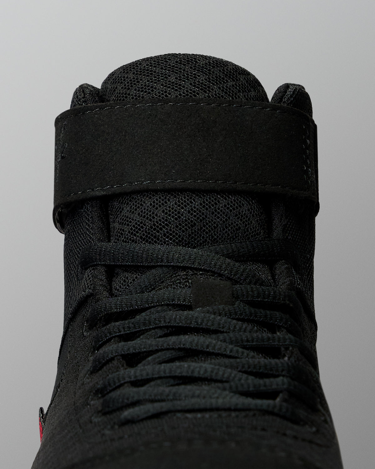 Close-up of the RUDIS Samurai Speed Youth Wabi-Sabi wrestling shoe, showing black laces, textured mesh tongue, and wide ankle strap with stitched detailing.