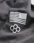A close-up view of a dark gray fabric featuring a white American flag design and a geometric honeycomb pattern
