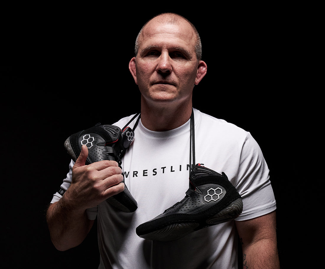 Cary Kolat holding RUDIS Kolat wrestling shoes Legacy core colorway showcasing athlete driven design and elite performance