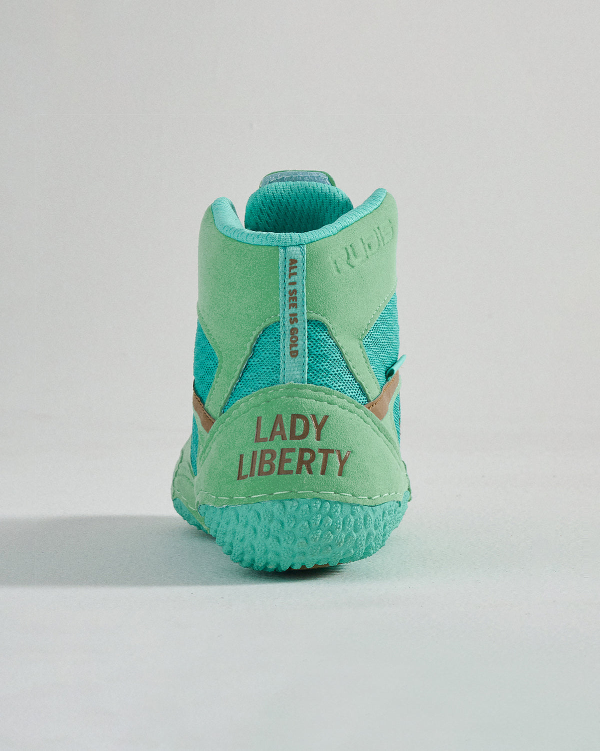 A stylish and vibrant turquoise sneaker featuring a unique Lady Liberty branding at the heel and a modern design perfect for casual wear