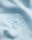 The image features a close-up of a light blue fabric with a hexagonal embroidered design highlighting texture and color
