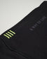 A close-up view of a black fabric featuring green stitching details and the phrase A WAY OF LIFE