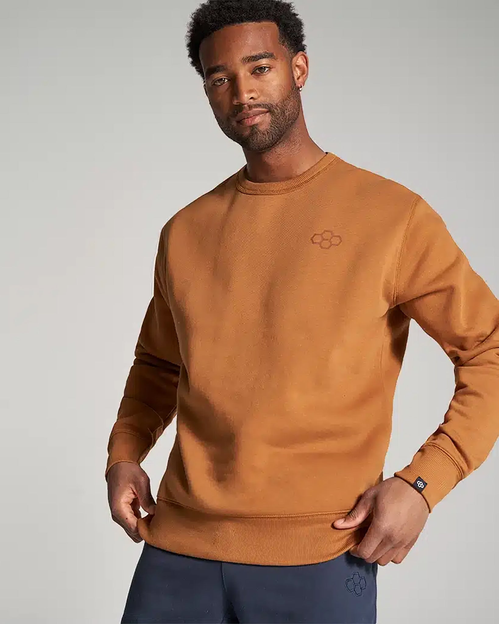 A man is wearing a stylish brown sweatshirt with a casual fit showcasing a simple design that is both modern and comfortable