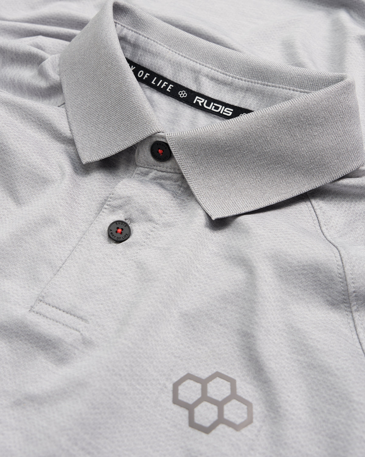 A detailed view of a light gray polo shirt featuring a stylish collar black buttons and a subtle honeycomb logo design