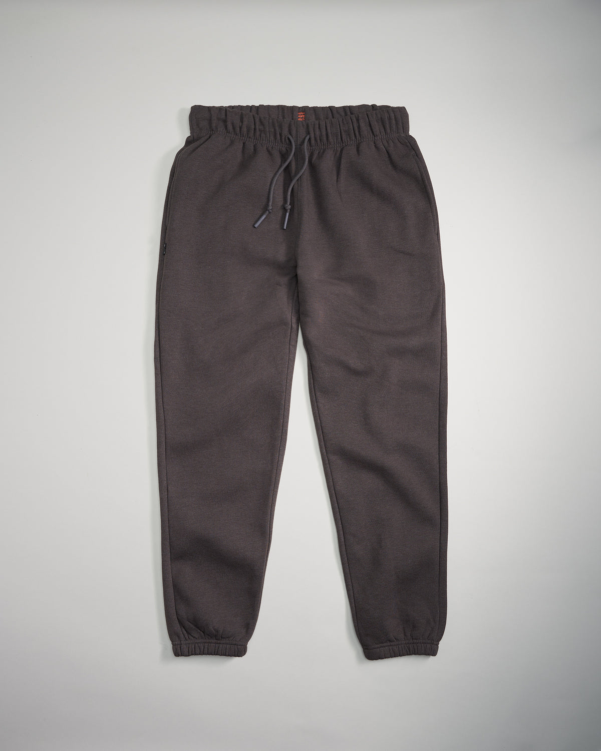 A pair of dark gray sweatpants featuring an elastic waist and tapered ankles ideal for comfort and casual wear