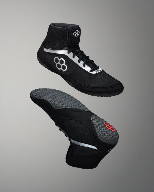 Black wrestling shoes with unique design elements on a gray background