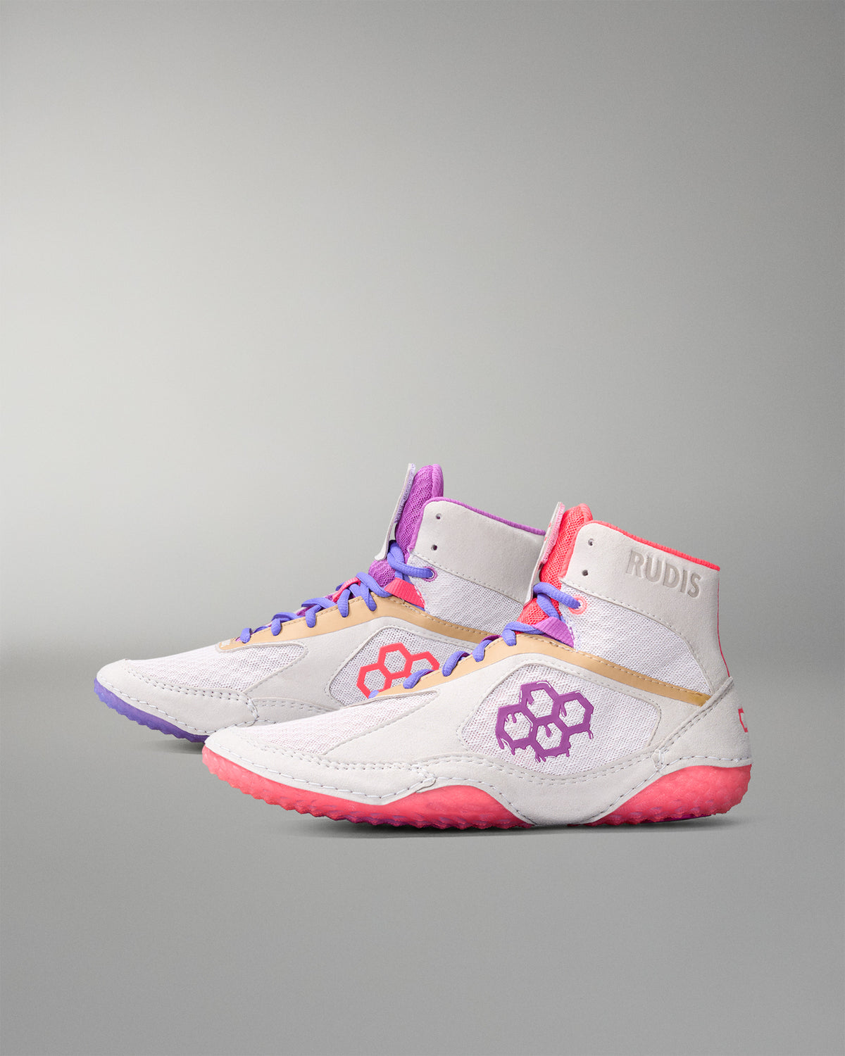 Pair of white wrestling shoe with pink and purple accents on a gray background