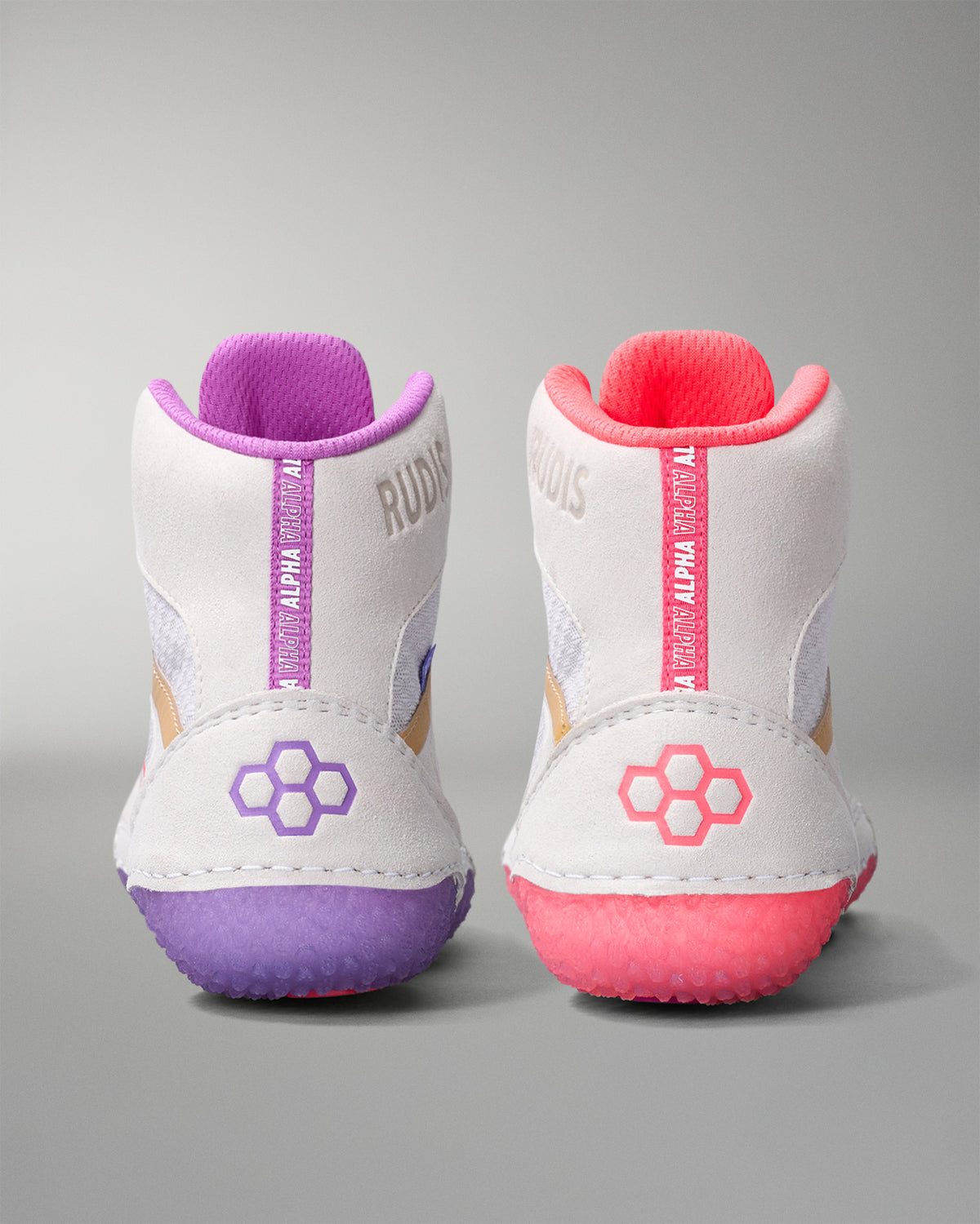 White wrestling shoes with purple and pink accents on a gray background