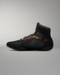 Black high-top sneaker with brown accents on a gray background