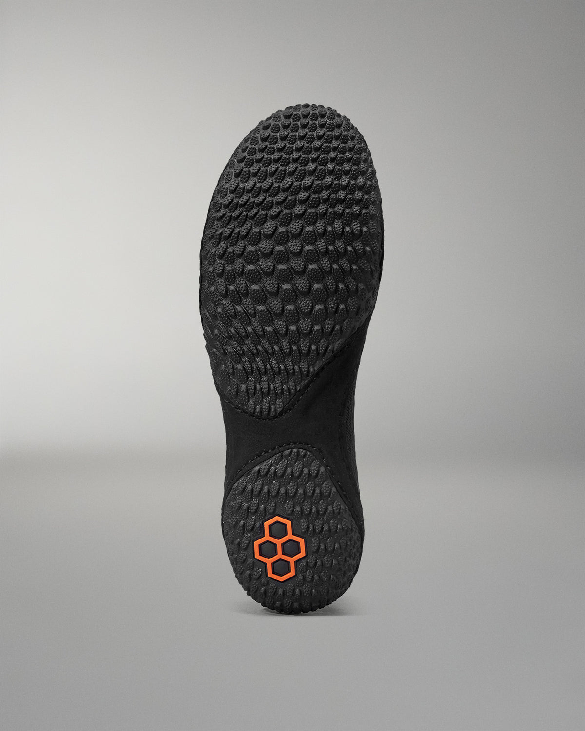 Black sole of a shoe with a textured pattern on a gray background