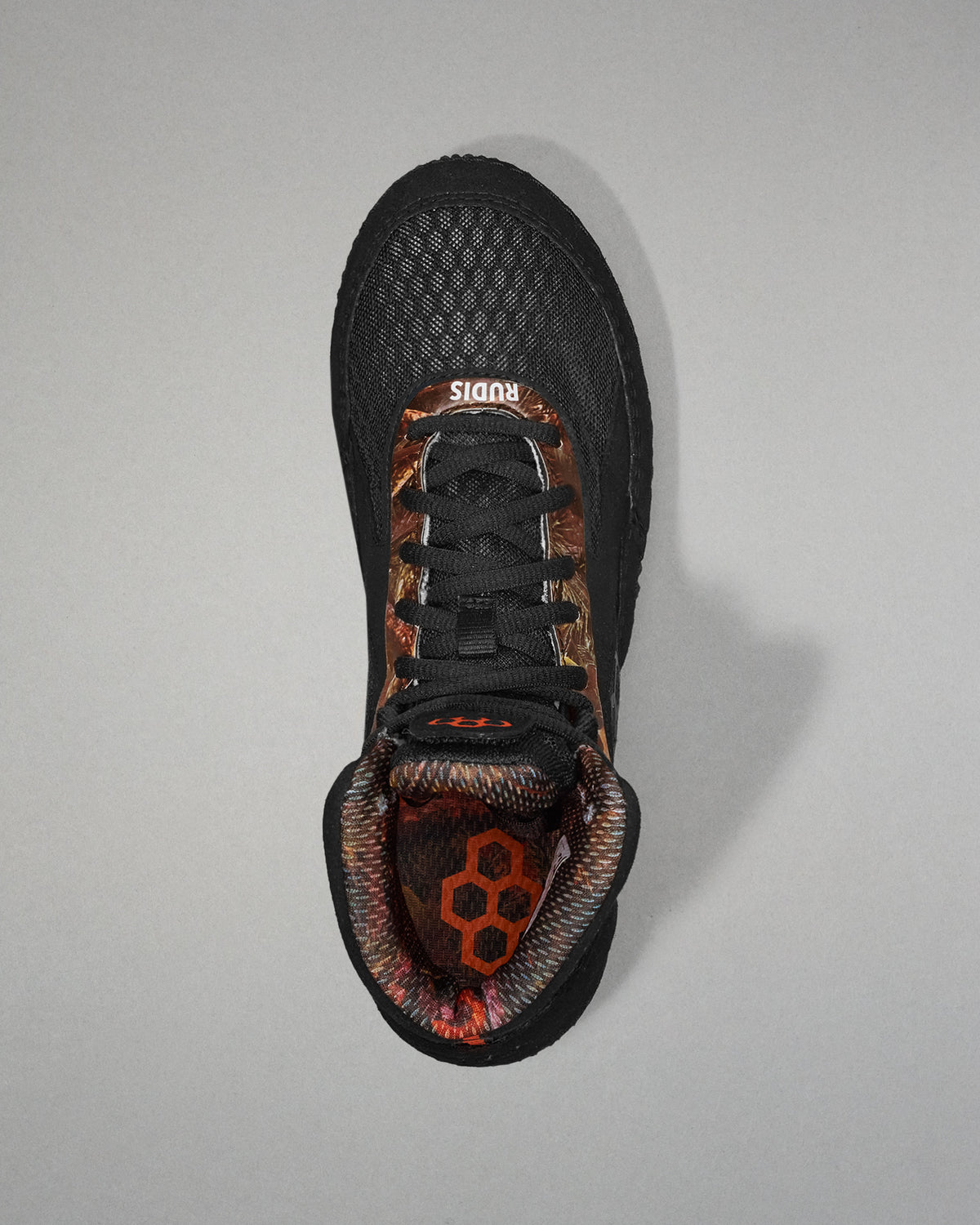 Black athletic shoe with camouflage pattern on a gray background