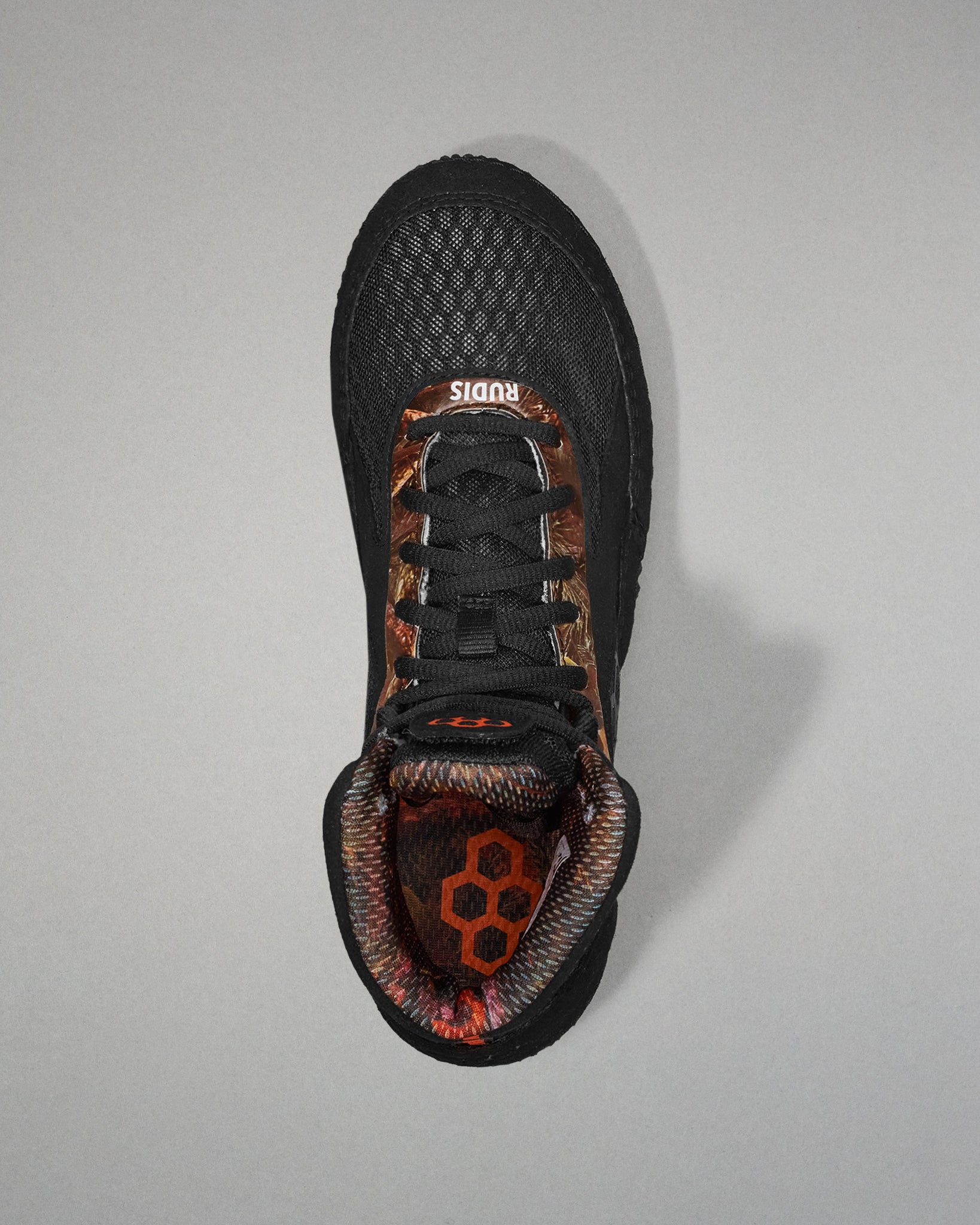 Black athletic shoe with camouflage pattern on a gray background