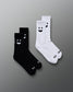 Two pairs of socks, one black and one white, with smiley face designs on a gray background.