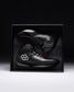 Black wrestling shoes with red accents in a black box on a dark background - Cary Kolat wrestling shoes