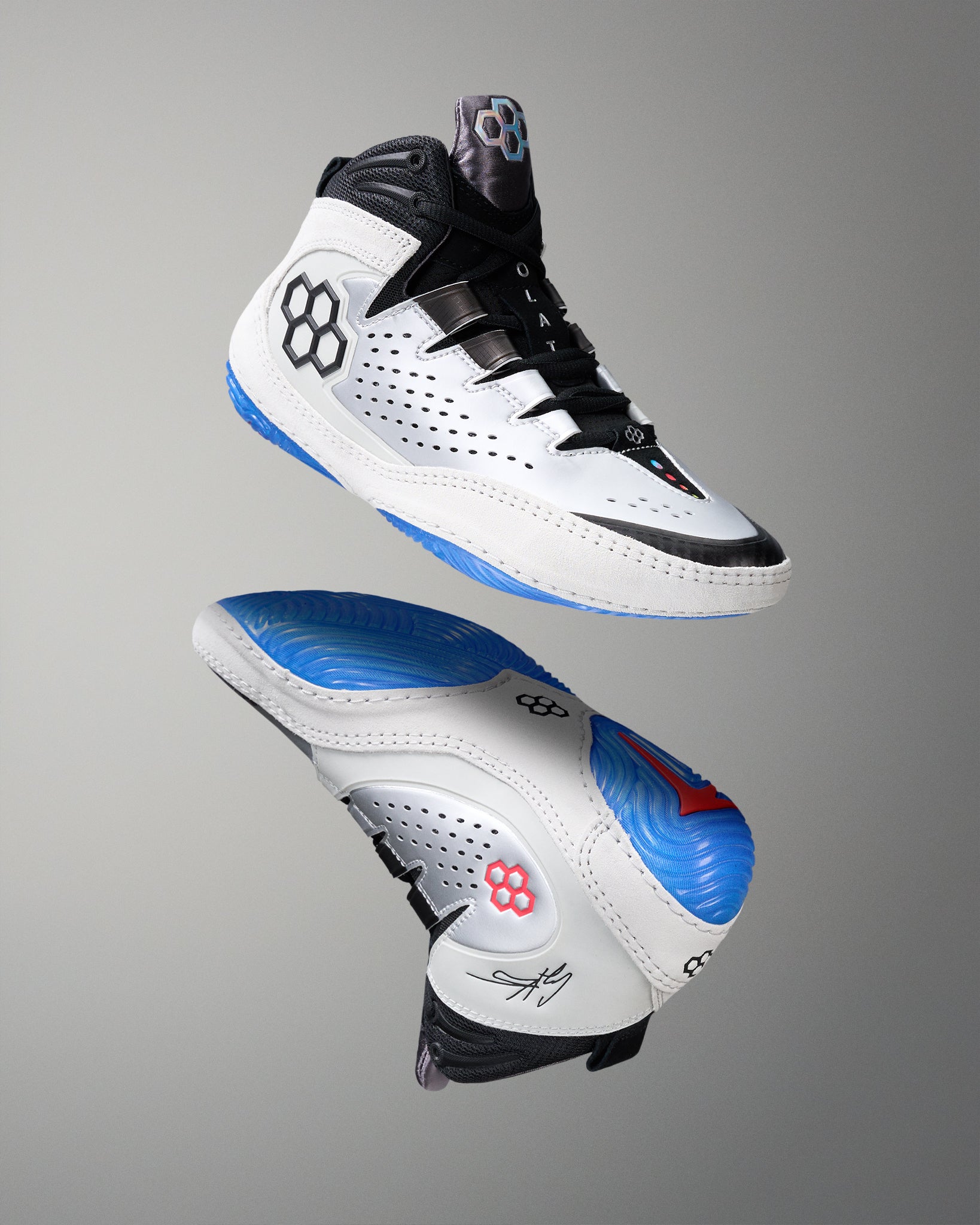 White wrestling shoes with black and blue accents on a gray background