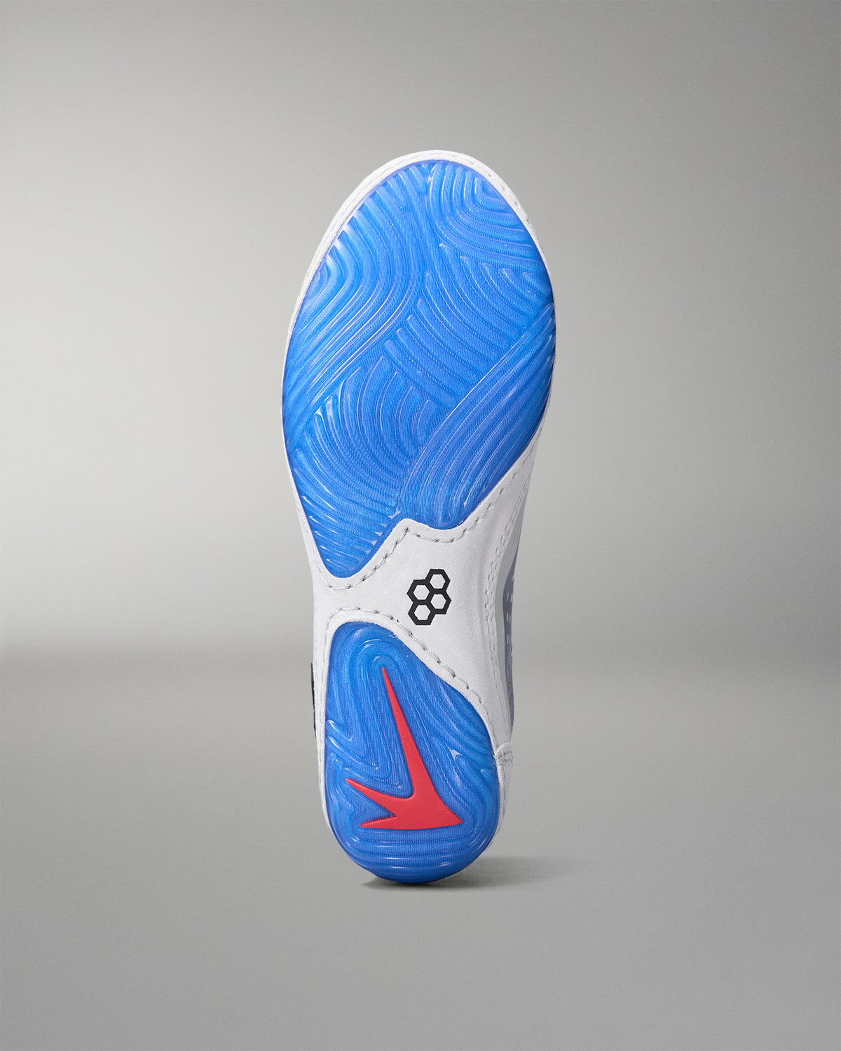 Sole of a wrestling shoe with blue tread pattern and red swoosh logo on a gray background