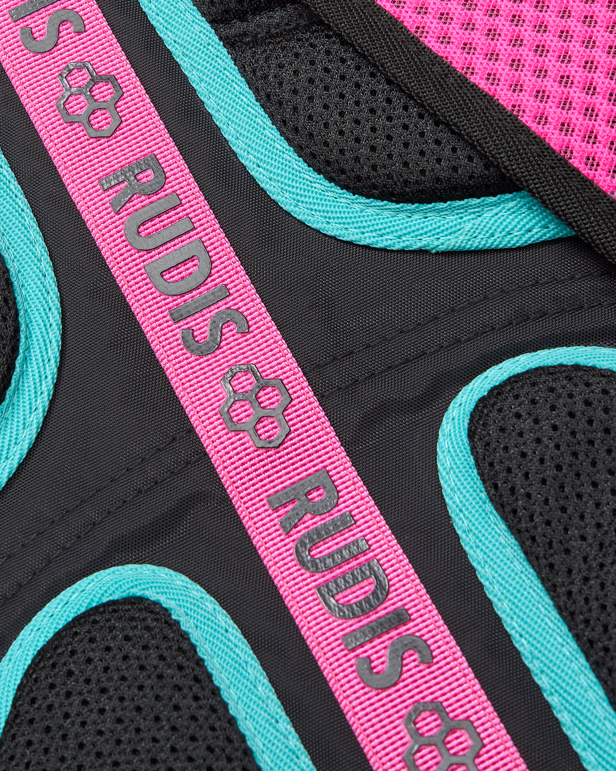 Close-up of a product with 'RUDIS' branding on a pink and teal strap.