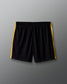 Black shorts with yellow stripes on a gray background