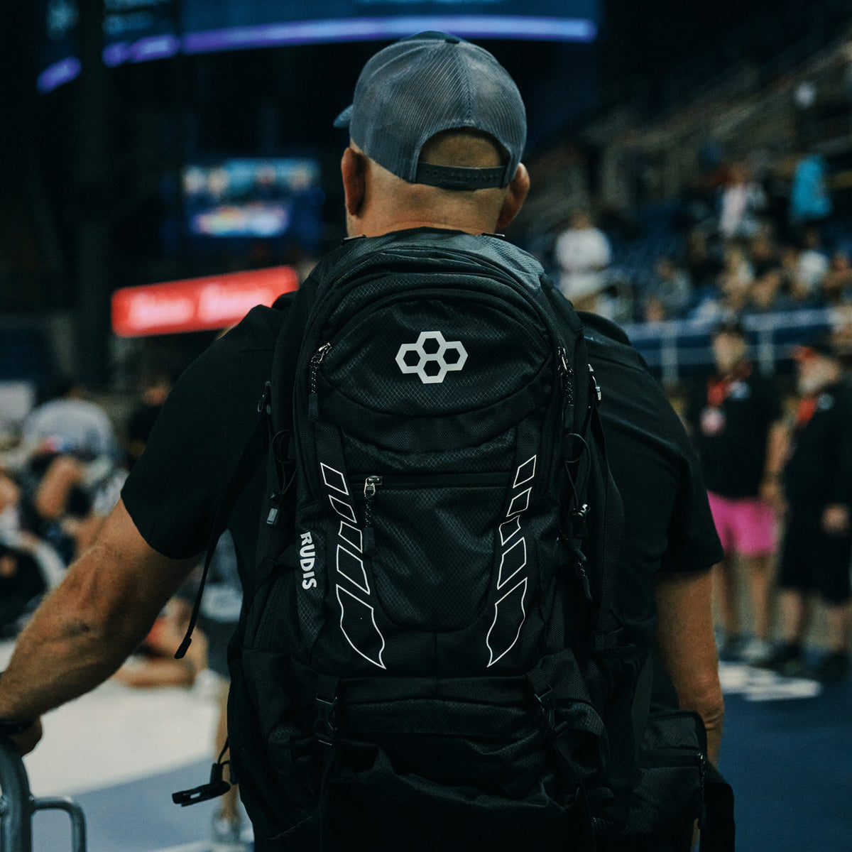 Person wearing a black backpack with a RUDIS at a wrestling tournament
