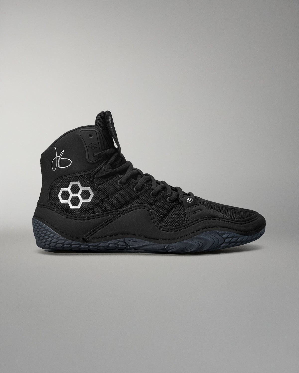 Black Jordan Burroughs wrestling shoes with a logo on a gray background