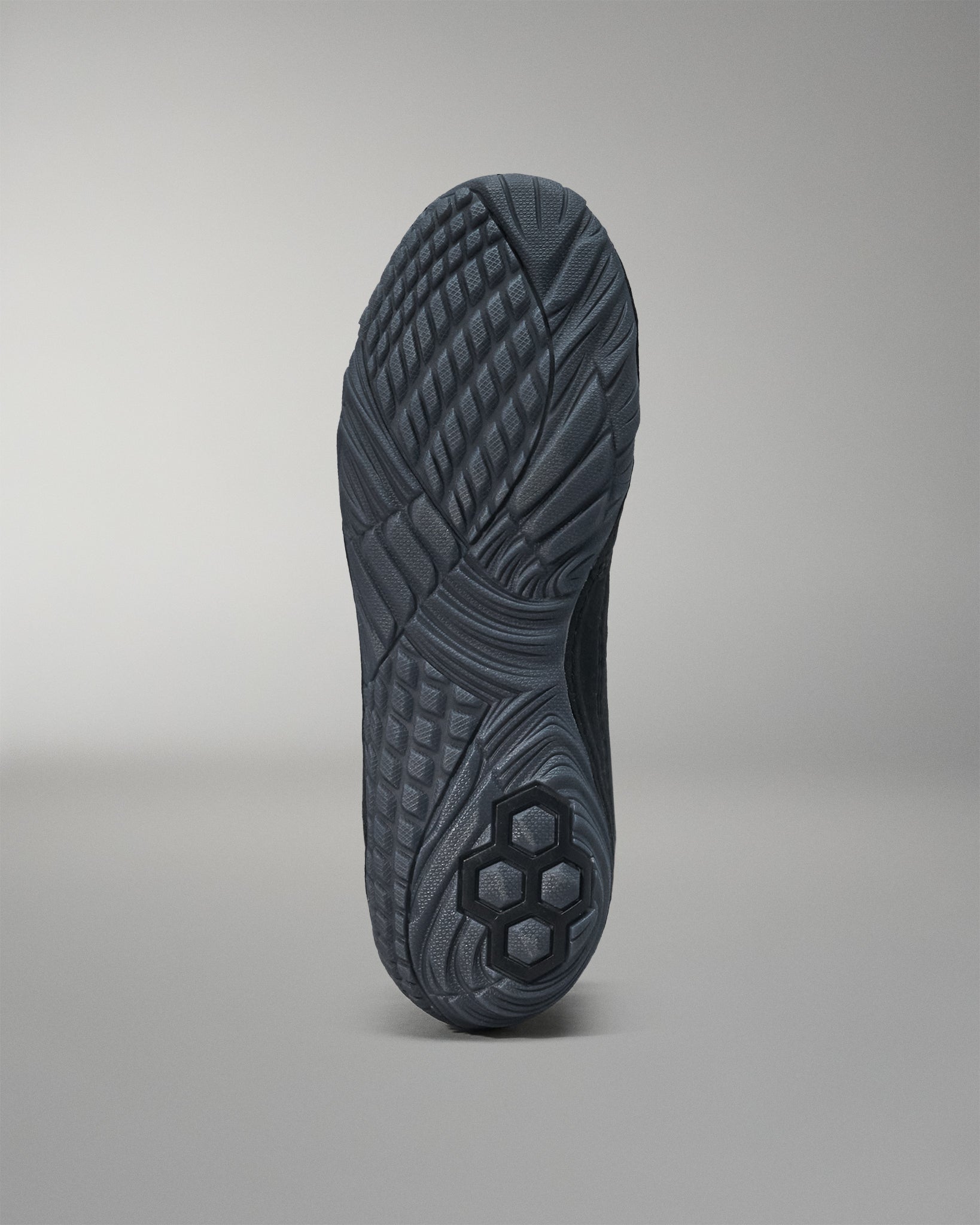 Close-up of a black Jordan Burroughs wrestling shoes bottom sole with tread pattern on a gray background