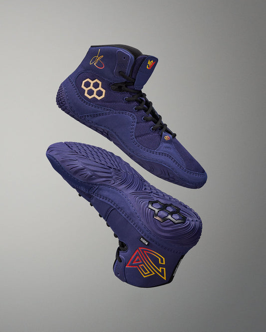 Blue wrestling shoes with brand logos on a gray background