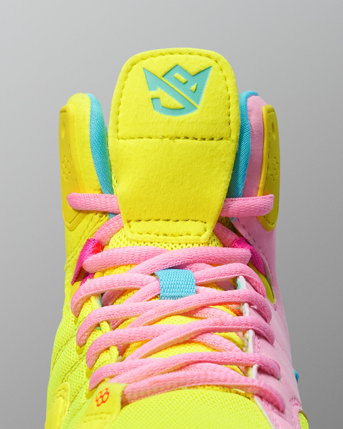 Brightly colored Wrestling shoe with pink laces on a gray background
