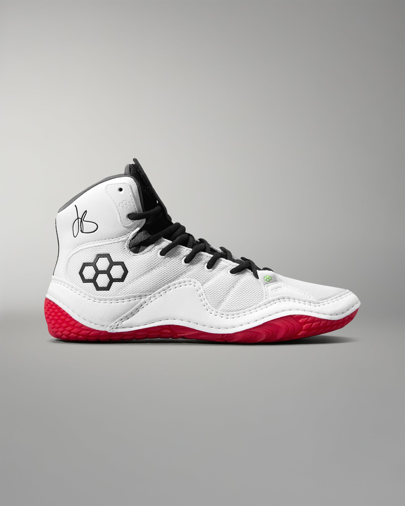 White wrestling shoe with black accents and red soles on a gray background