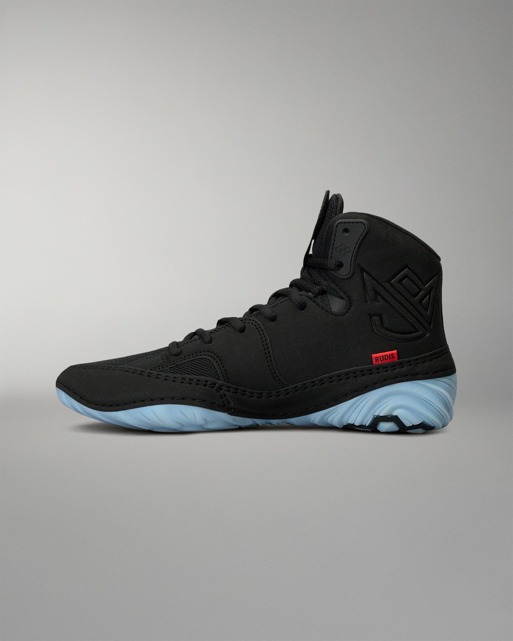 RUDIS JB1 Adult Wrestling Shoe in Dark Shark shown from the medial side, featuring the black high-top construction, tonal JB branding, red RUDIS accent, and light blue outsole.