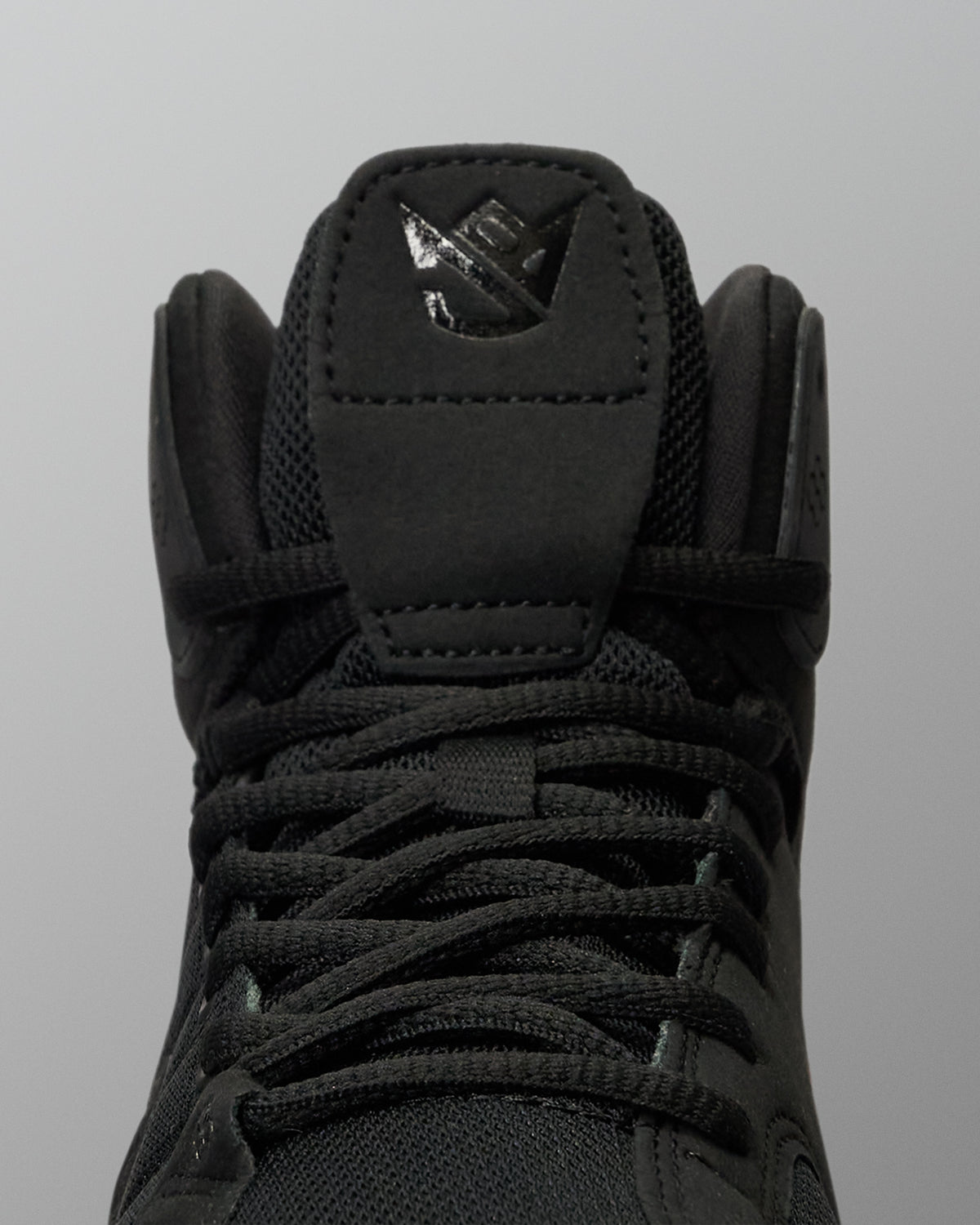 RUDIS JB1 Adult Wrestling Shoe in Dark Shark shown in a close-up front view, highlighting the black lacing system, mesh tongue, padded collar, and tonal JB tongue logo.