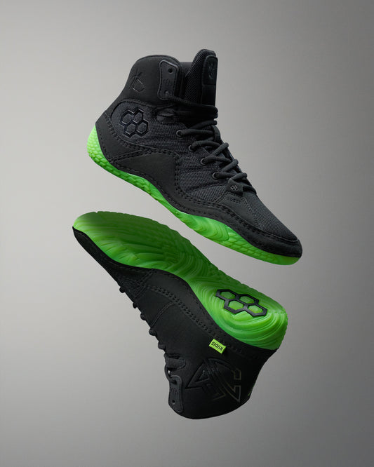 Black Wrestling shoes with green soles on a gray background