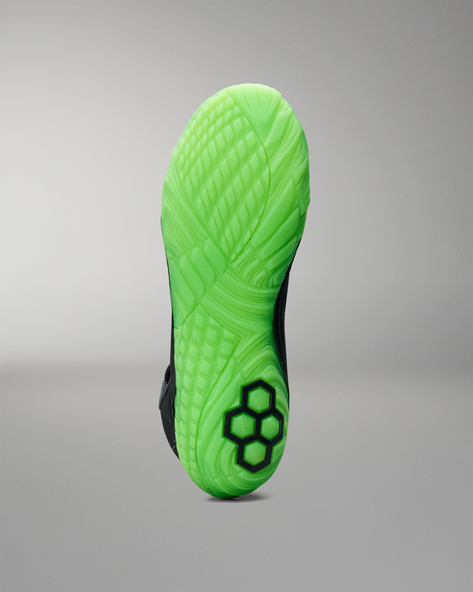 Green sole of a Wrestling shoe with a textured pattern on a gray background