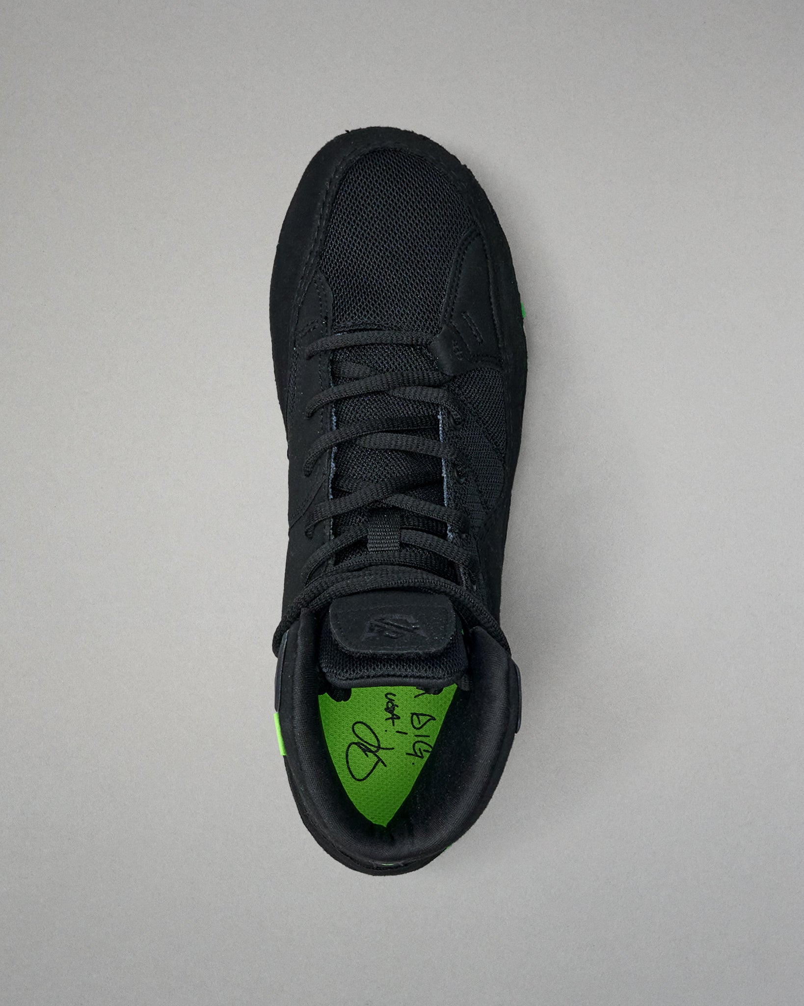 Black Wrestling shoe with a green sole on a gray background