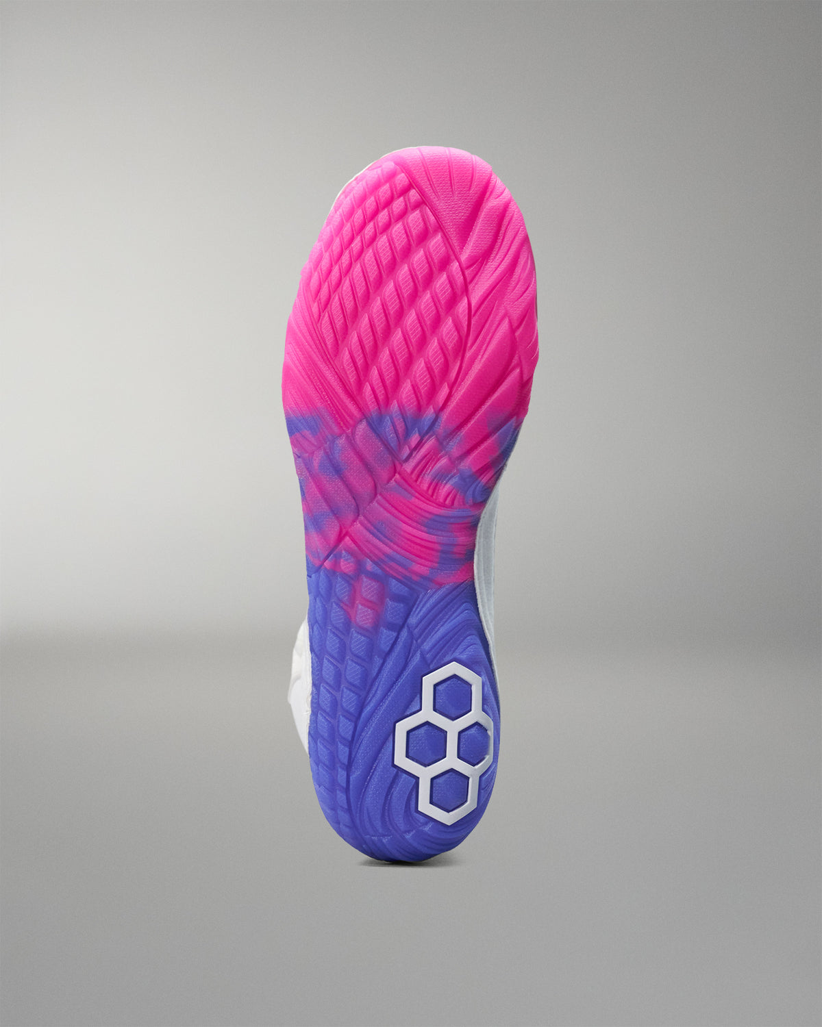 Close-up of a pink and blue wrestling shoe sole on a gray background