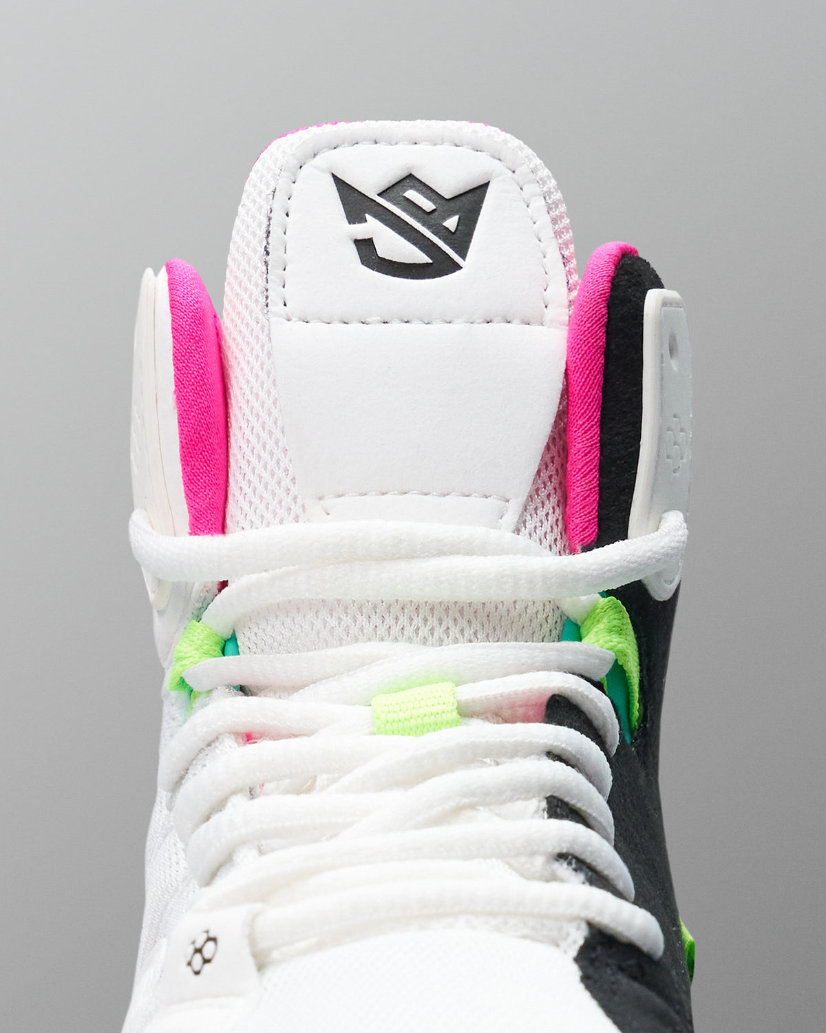 Close-up of a white wrestling shoe with colorful laces on a gray background