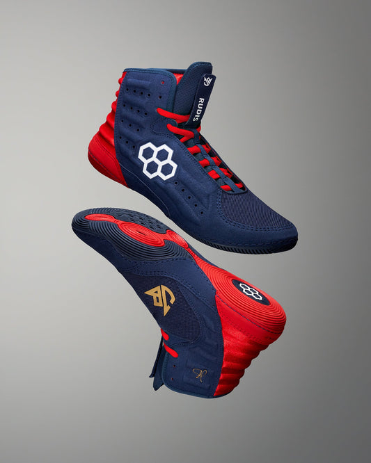 Navy and red wrestling shoes with brand logos on a gray background