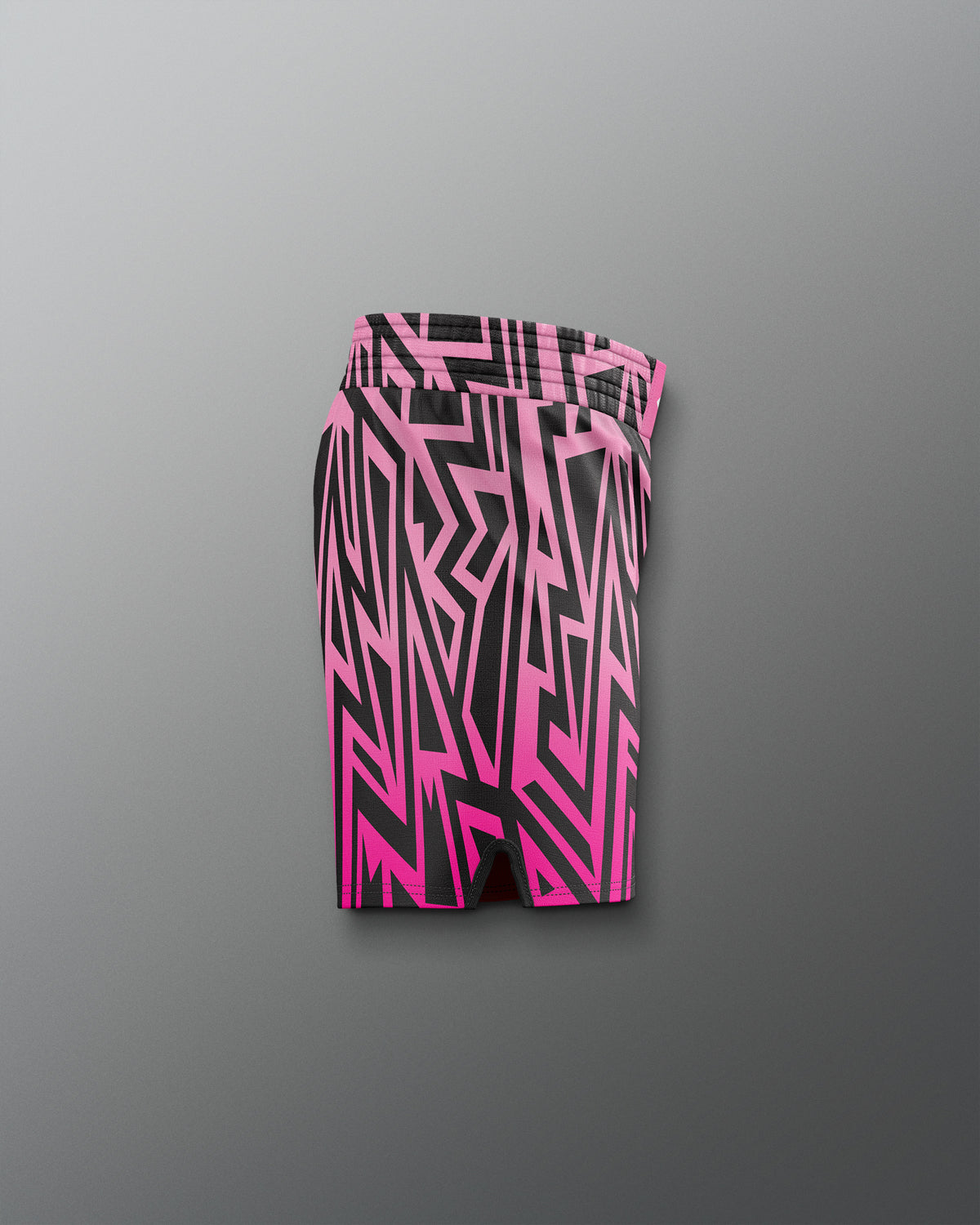 Pink and black geometric patterned shorts on a gray background