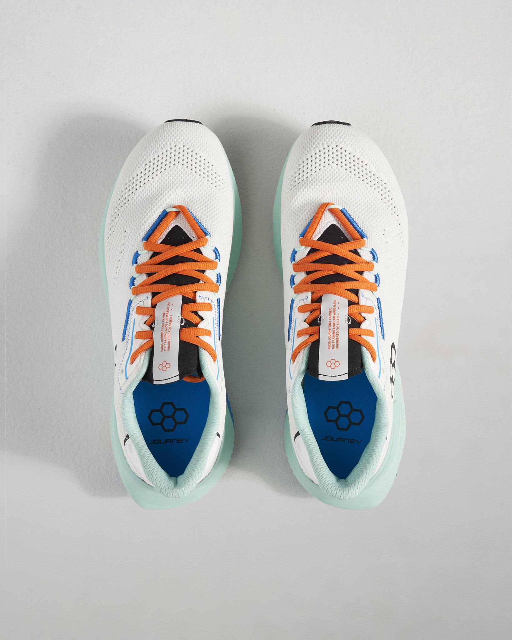 Top view of a modern white athletic shoe with orange and blue accents showcasing breathable mesh and a lightweight design
