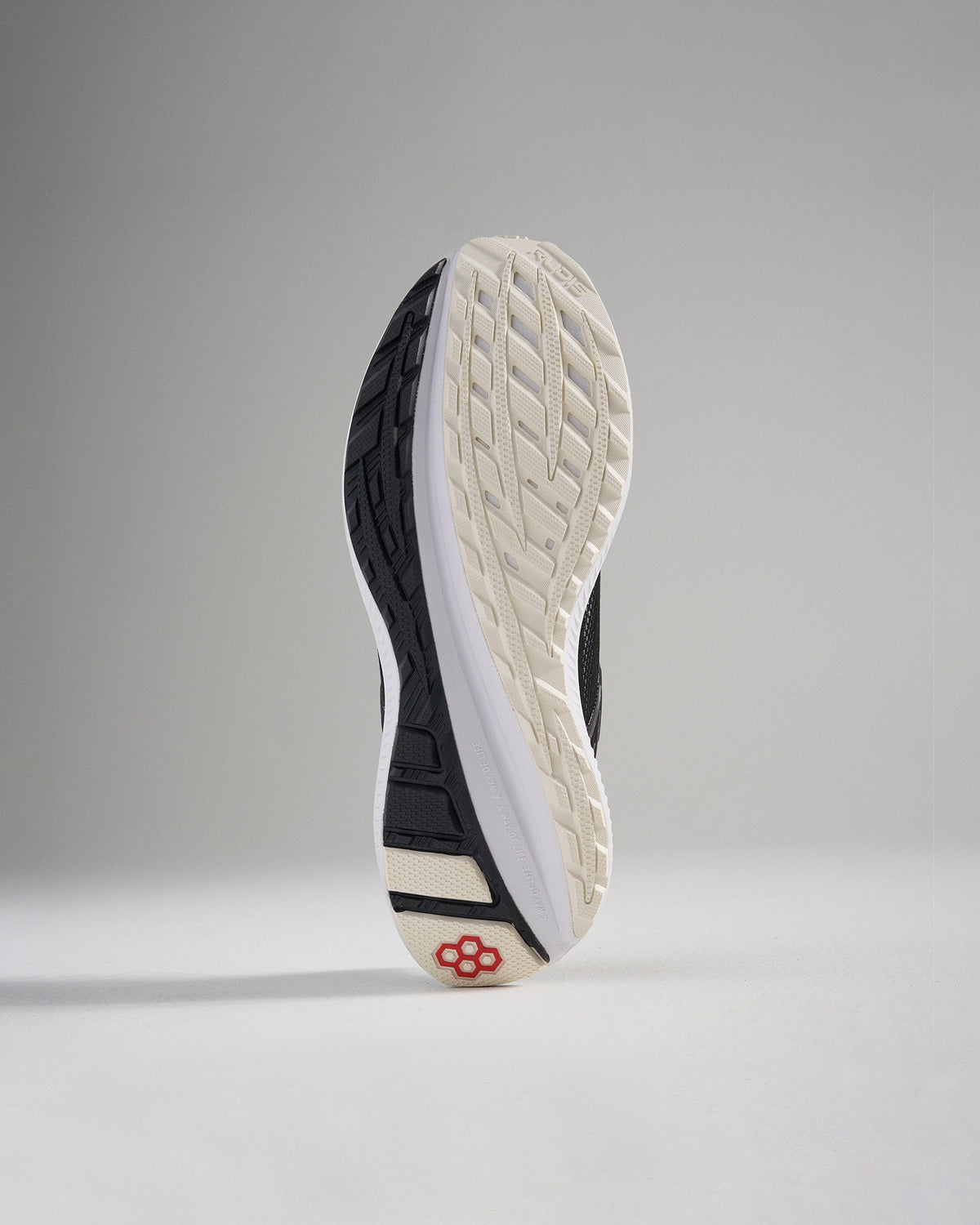 A close-up view of a shoes sole featuring a textured black and white design for traction and durability
