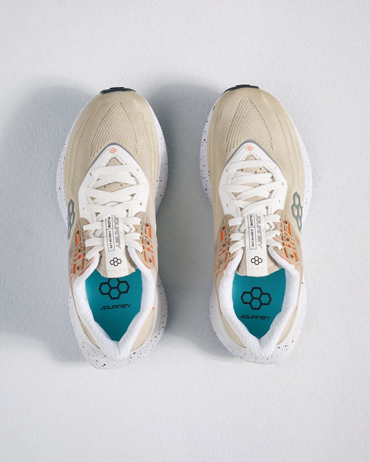 A pair of beige and white athletic shoes with a breathable mesh upper and colorful detailing accompanied by a snug fit for comfort during physical activities