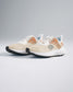 A stylish pair of lightweight beige running shoes featuring a breathable mesh upper with orange styling designed for both comfort and performance