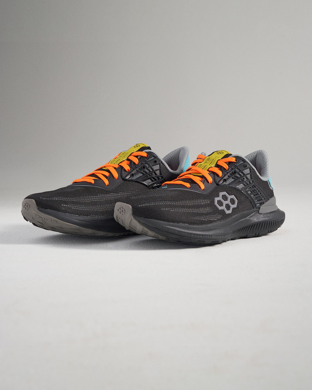 Sleek black athletic shoes with vibrant orange laces and modern design elements ideal for running or casual wear