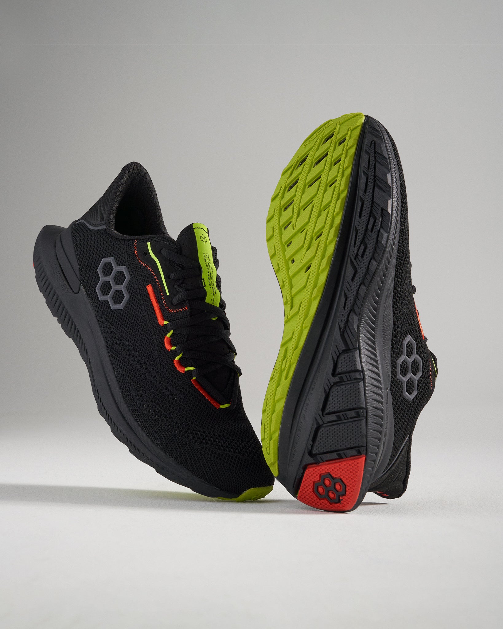 This image showcases modern black athletic shoes featuring vibrant neon accents and a textured sole for enhanced grip